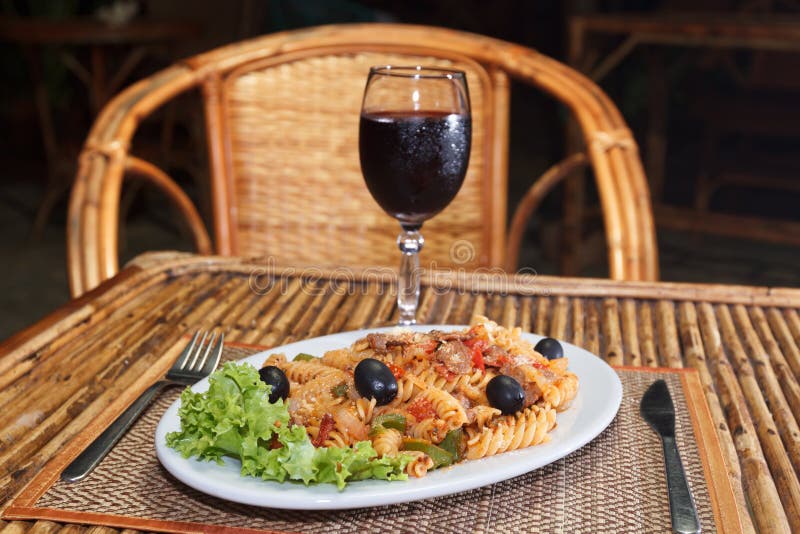 Natural light photo with shallow DOF of macaroni pasta with bolognese sauce and parmesan cheese on a white plate and glass of red wine view 2. Natural light photo with shallow DOF of macaroni pasta with bolognese sauce and parmesan cheese on a white plate and glass of red wine view 2