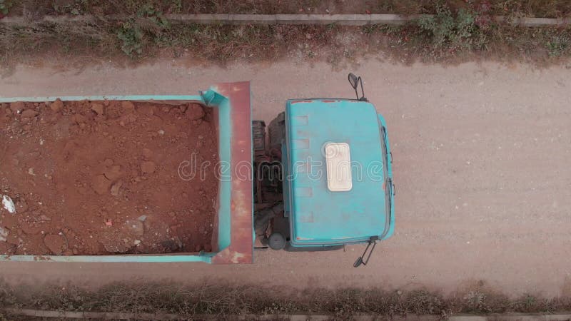 通过土路运输土壤的空中观察施工卡车 . 建筑业中的活动机器. 无人机的顶角