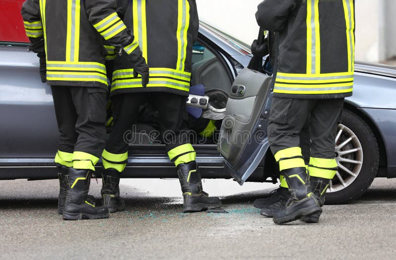 一支消防队在紧急情况下营救车祸中受伤的人员，事故发生于道路上 库存图片