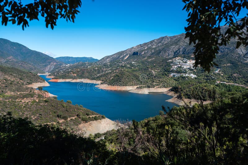 郁郁葱葱的宁静山湖，蓝天清澈的远村 免版税库存照片