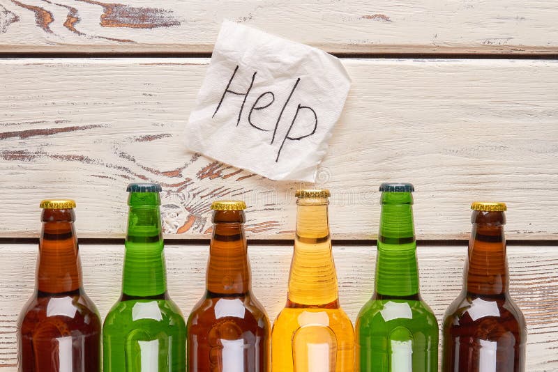 Help to be saved from alcoholism. Paper message above set of bottles with alcohol. Help to be saved from alcoholism. Paper message above set of bottles with alcohol.