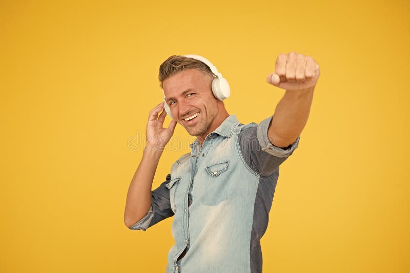 Cool man enjoy music. his favorite playlist. dj party. happy man dancing yellow background. listen to music in headphones. catch the tune. i like this track. melody to dance. sexy guy in disco mood. Cool man enjoy music. his favorite playlist. dj party. happy man dancing yellow background. listen to music in headphones. catch the tune. i like this track. melody to dance. sexy guy in disco mood.