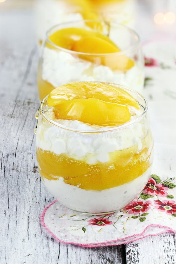 Cottage cheese with fresh peaches and honey on a rustic background. Shallow depth of field. Cottage cheese with fresh peaches and honey on a rustic background. Shallow depth of field.