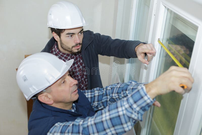 两名工人正在测量窗户 库存照片