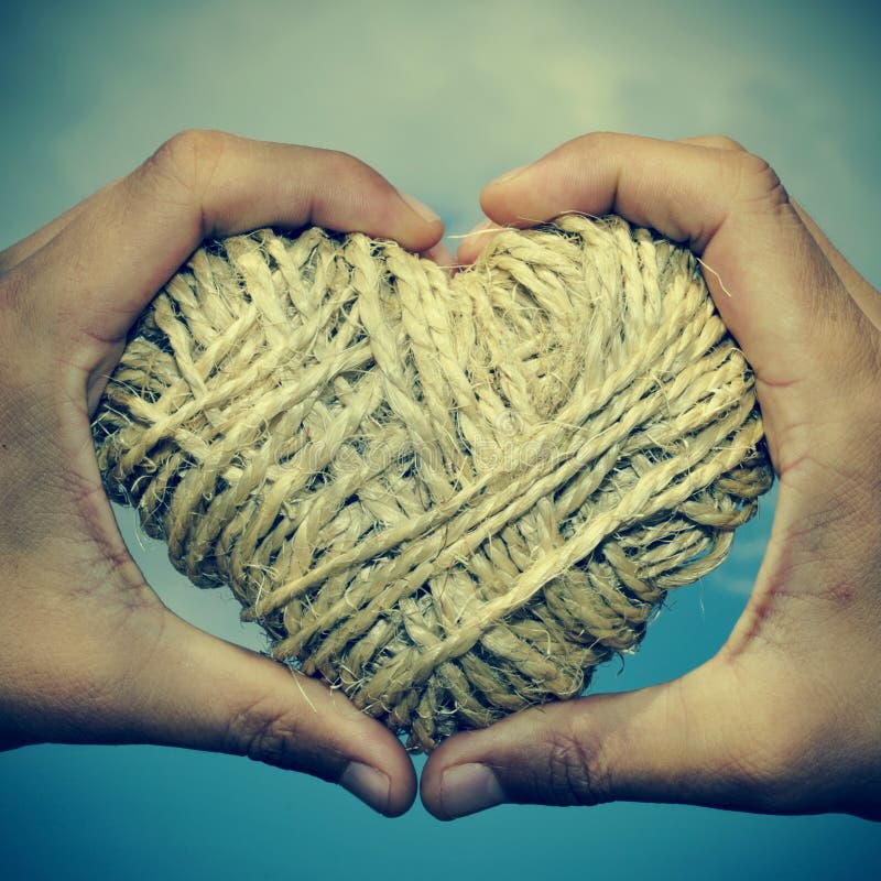 Man hands forming a heart showing a heart-shaped coil of rope. Man hands forming a heart showing a heart-shaped coil of rope