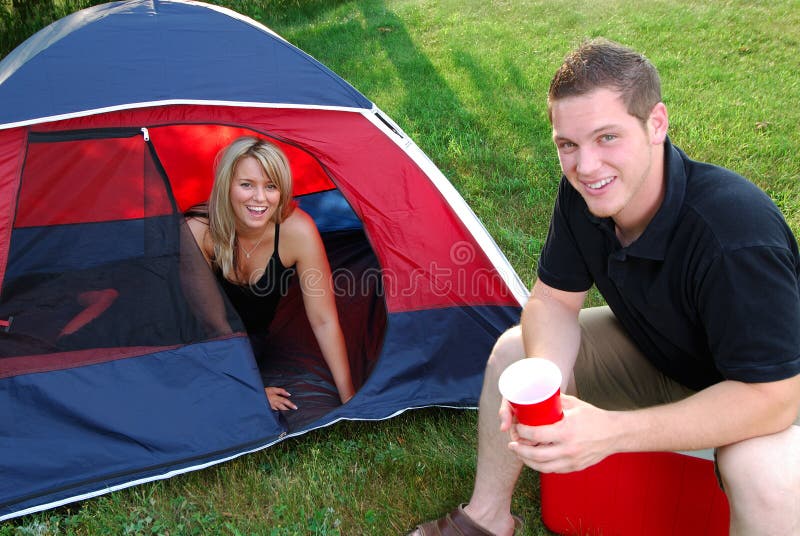 Young Attractive Couple Camping In A Tent In The Countryside. Young Attractive Couple Camping In A Tent In The Countryside