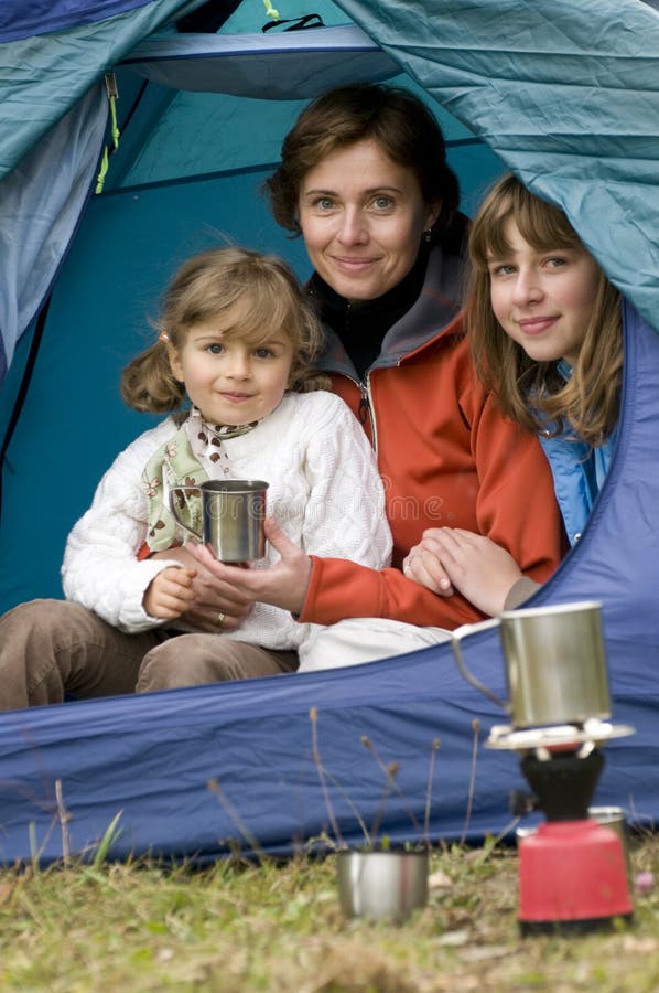 Mother and daughters camping in tent. Mother and daughters camping in tent