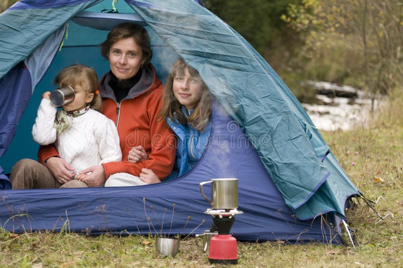 Mother and daughters camping in tent. Mother and daughters camping in tent