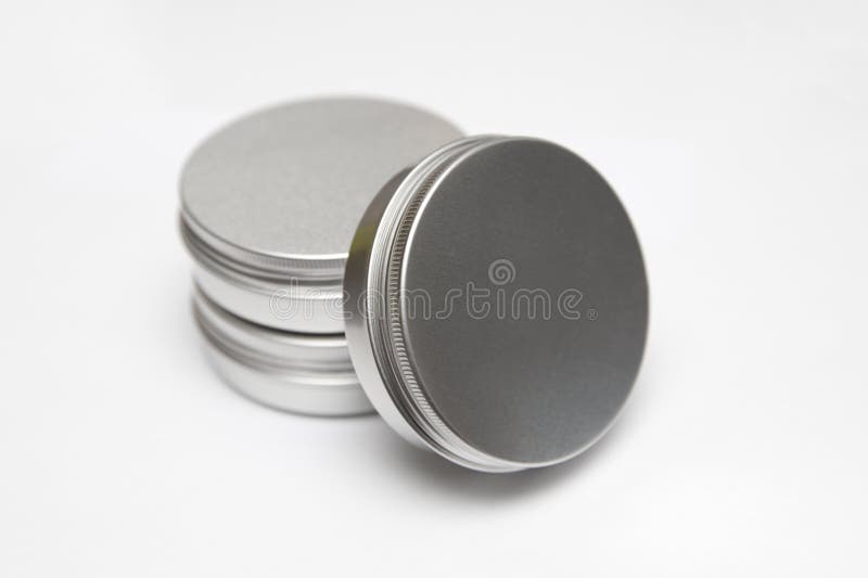 Lip balm in the round metallic tins isolated on the white background. Lip balm in the round metallic tins isolated on the white background
