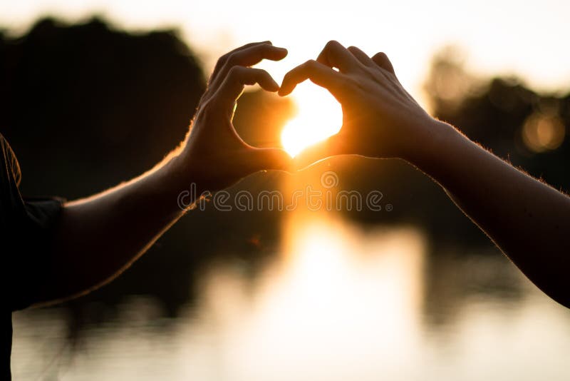 金色夕阳背景的手形心形 免版税库存图片 金色夕阳背景的手形心形 免版税库存图片