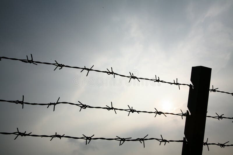 Barbed wire in silhouette to keep people in or keep people out. Barbed wire in silhouette to keep people in or keep people out