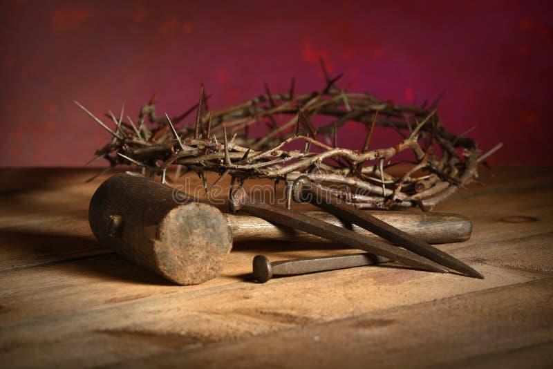 Crown of thorns, mallet and nails over vintage table over red background. Crown of thorns, mallet and nails over vintage table over red background