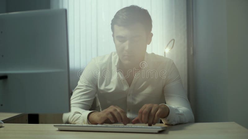 键入在一个无线键盘的一个年轻英俊的办公室工作者的画象