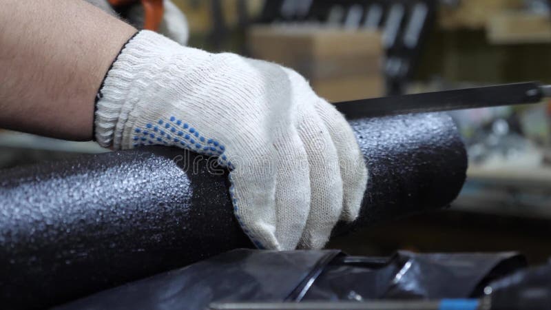 锯有引形钢锯的特别手套的工人管子 专业管子切口工作者 特写镜头
