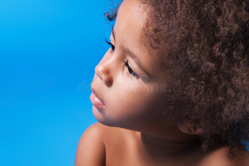 Face portrait of a calm little child on a blue background. Face portrait of a calm little child on a blue background