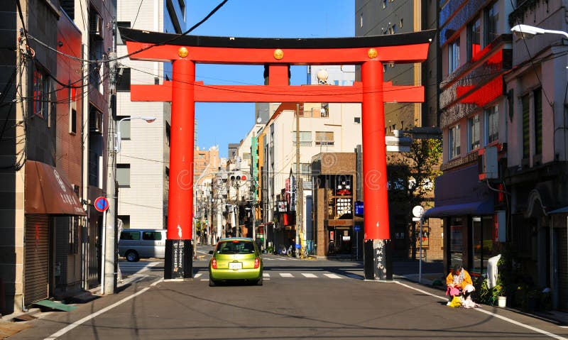 Tokyo, Japan - 31 December, 2011: Traditional Shinto temple gate against modern architecture on the streets of Asakusa, Tokyo. Tokyo, Japan - 31 December, 2011: Traditional Shinto temple gate against modern architecture on the streets of Asakusa, Tokyo