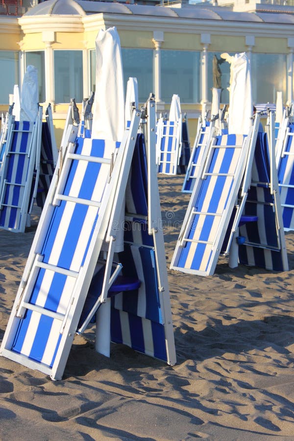 Closed deckchairs in a beach at sunset. Closed deckchairs in a beach at sunset