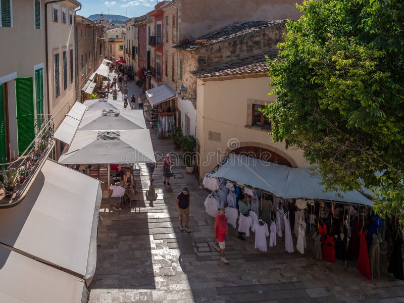 阿尔库迪亚市场，马略卡岛，色彩缤纷的建筑林立的迷人小镇中的热闹街道，设有户外咖啡馆和服装 图库摄影