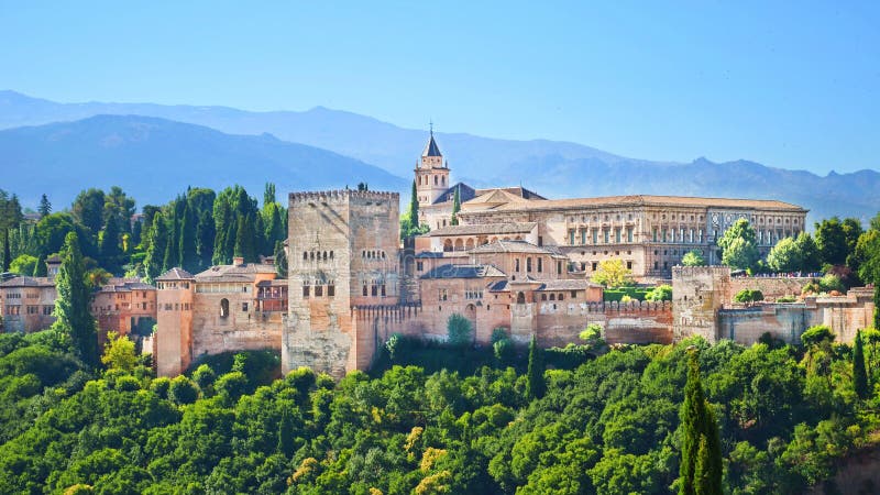 Beautiful Alhambra Palace complex in Spanish Granada on a sunny day captured on 16:9 photography. The amazing fortress and popular tourist spot is surrounded by green woods and mountains. Beautiful Alhambra Palace complex in Spanish Granada on a sunny day captured on 16:9 photography. The amazing fortress and popular tourist spot is surrounded by green woods and mountains