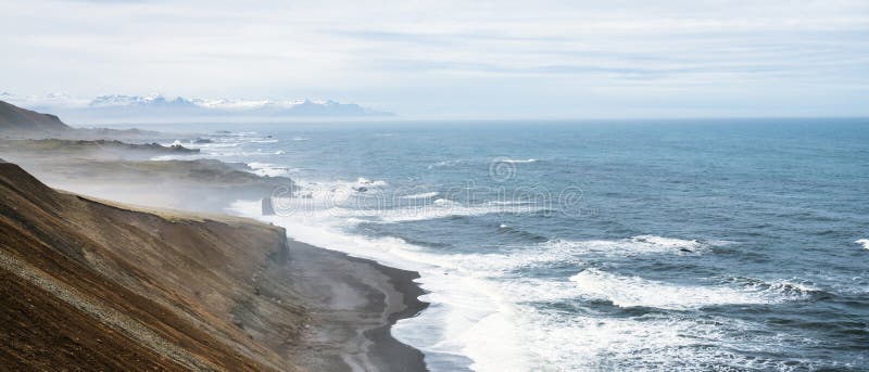 陡峭的悬崖边,火山海滩和海浪汹涌而至 图库摄影