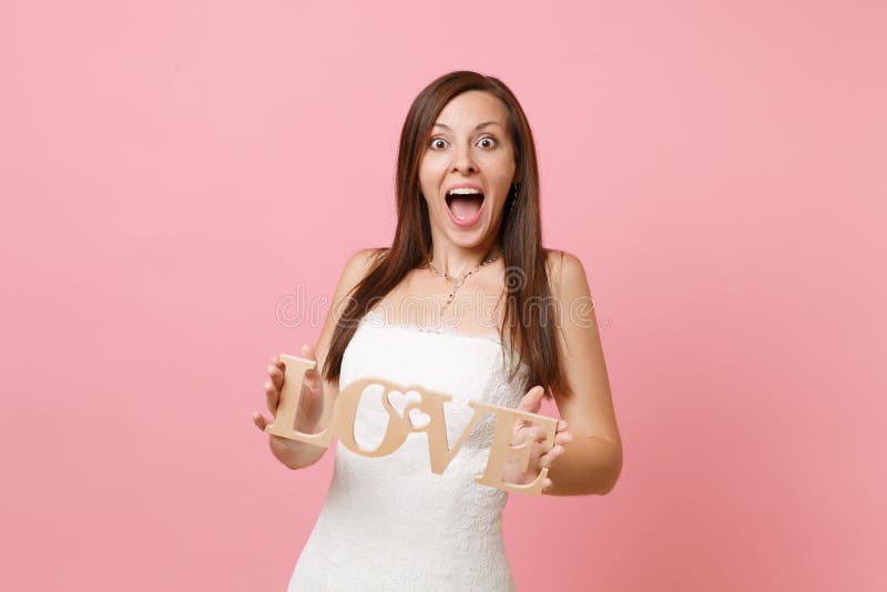 震惊激动的新娘妇女画象鞋带白色婚纱身分和举行的木词信件爱 库存照片 震惊激动的新娘妇女画象鞋带白色婚纱身分和举行的木词信件爱 库存照片
