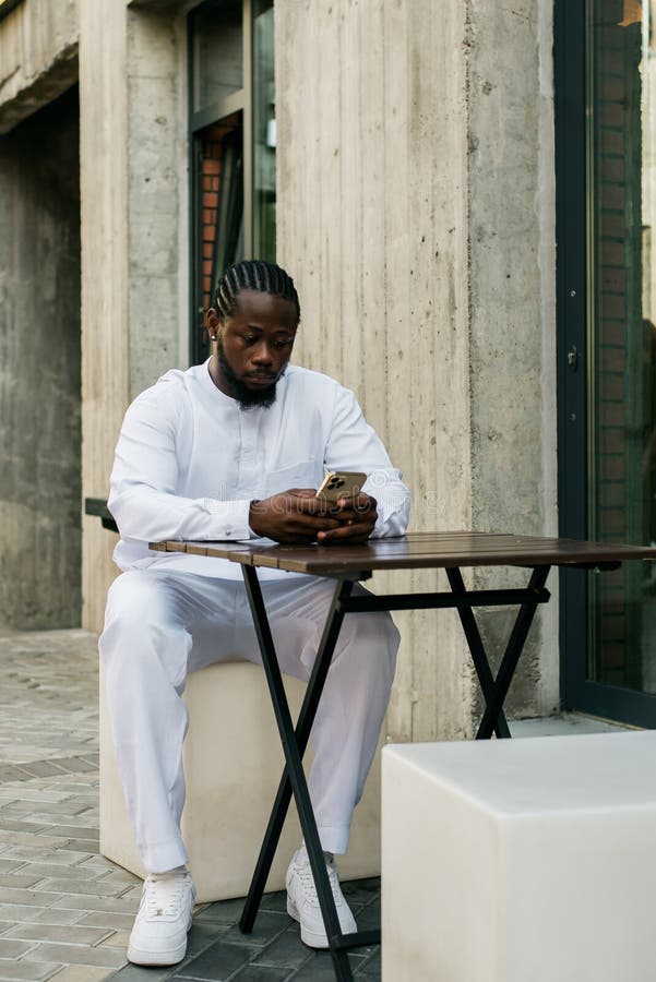 African american man checks cell phone in the street cafe in summer day. Millennial generation and gen z people. Social networks and dating app. African american man checks cell phone in the street cafe in summer day. Millennial generation and gen z people. Social networks and dating app