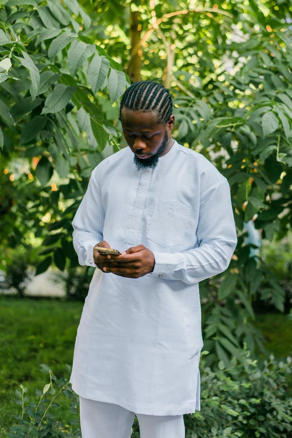 African american man checks cell phone in the street cafe in summer day. Millennial generation and gen z people. Social networks and dating app. African american man checks cell phone in the street cafe in summer day. Millennial generation and gen z people. Social networks and dating app