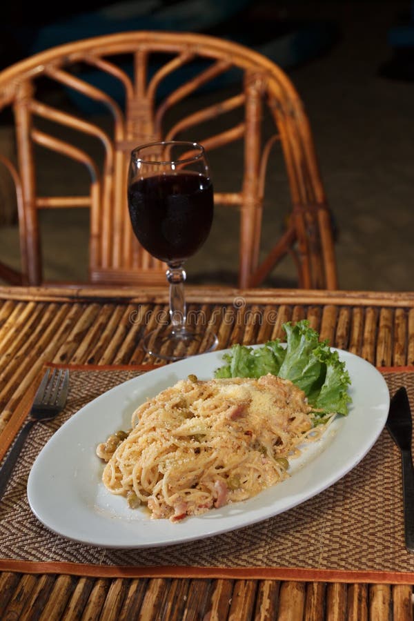 Natural light photo with shallow DOF of a plate of pasta topped with cheese and with glass of wine view 2. Natural light photo with shallow DOF of a plate of pasta topped with cheese and with glass of wine view 2