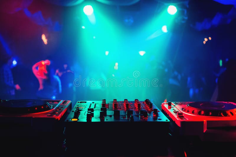 Music mixer controller in DJ booth on dance floor background in night club at party. Music mixer controller in DJ booth on dance floor background in night club at party