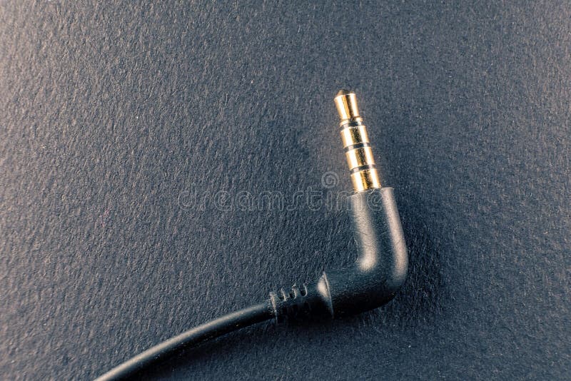 A representation of the audio technology and art, a golden plated 3.5mm jack on a black background symbolizes the connection between sound and design. A representation of the audio technology and art, a golden plated 3.5mm jack on a black background symbolizes the connection between sound and design.