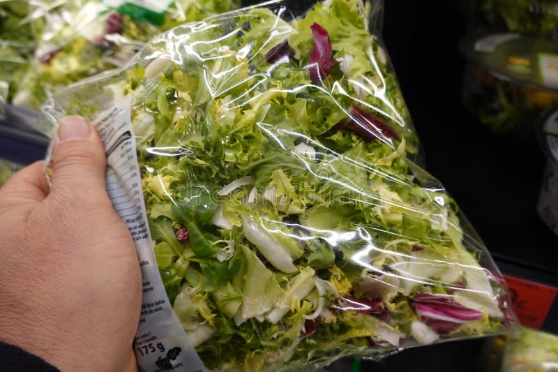 顾客在超市选择新鲜袋装沙拉 免版税图库摄影
