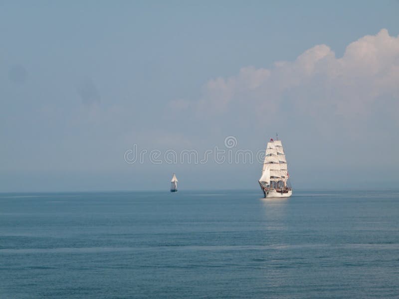 Two traditional sailing ships at sea under full sail. Two traditional sailing ships at sea under full sail