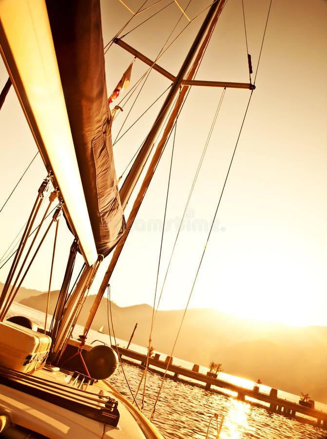 Sailboat on sunset, luxury yacht in the sea, romantic vacation and travel, bright light in the sky, peaceful beach view, water sport, freedom and adventure concept. Sailboat on sunset, luxury yacht in the sea, romantic vacation and travel, bright light in the sky, peaceful beach view, water sport, freedom and adventure concept