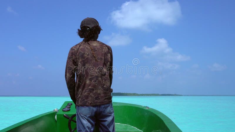 马尔代夫2017年3月30日 : 印度洋上驾驶摩托艇的男子的后视