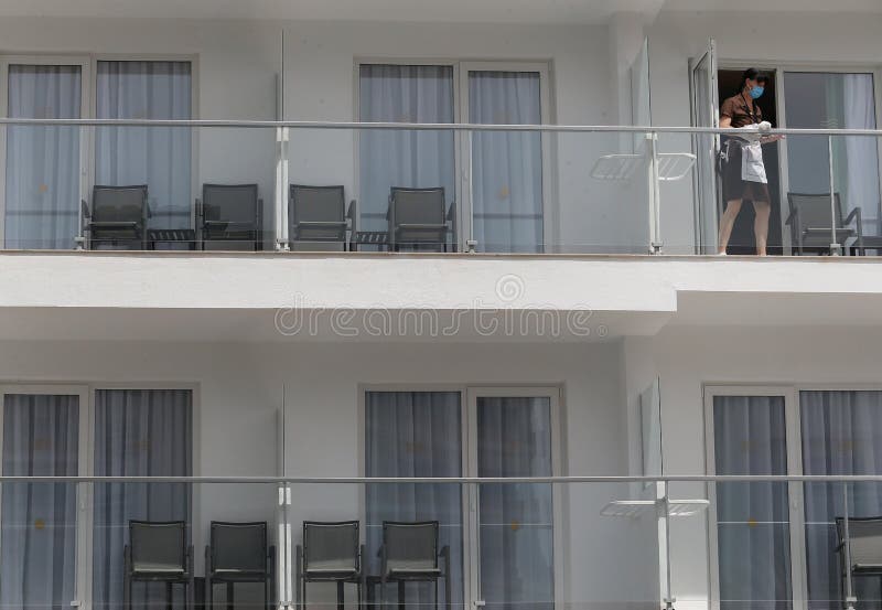 马略卡一家酒店阳台上的玻璃清洁工戴着防护口罩清洁玻璃