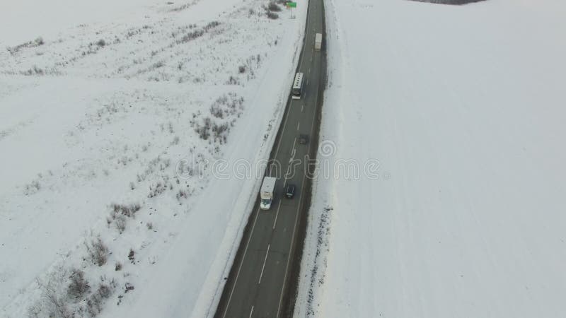 驾驶在多雪的领域的车和公共汽车空中射击冬天路