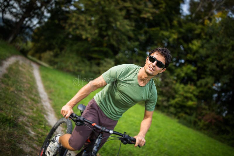 骑他的登山车的年轻人户外 库存图片 骑他的登山车的年轻人户外 库存图片