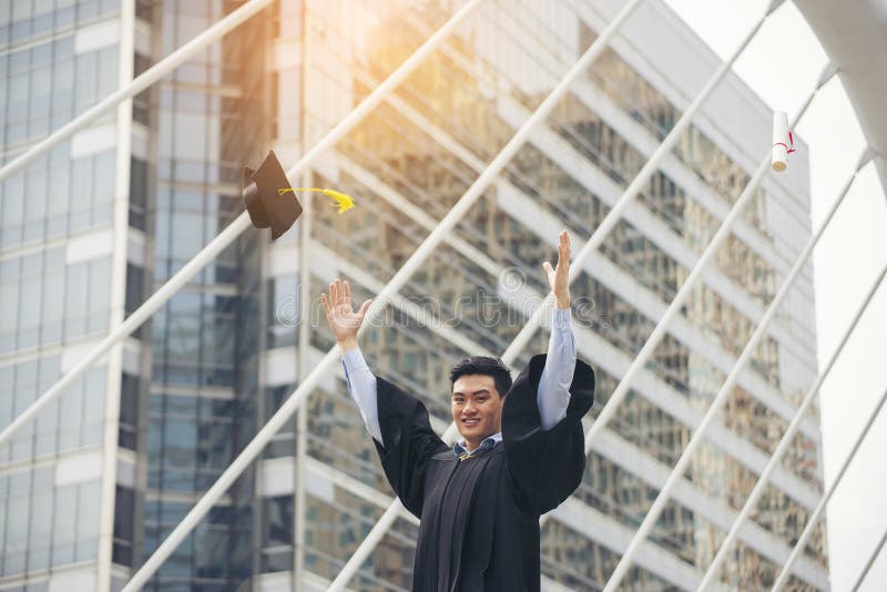 高兴亚洲女学生,获大学研究生文凭和MBA学位,穿着学术服装和帽子 研究生和 图库摄影 高兴亚洲女学生,获大学研究生文凭和MBA学位,穿着学术服装和帽子 研究生和 图库摄影