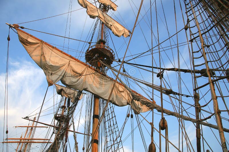 Detail of old sailing ship. Mast of a ship with furled sails detail. Detail of old sailing ship. Mast of a ship with furled sails detail.