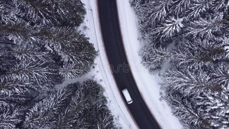 高空俯视雪林山，驾驶汽车驾驶冬路.