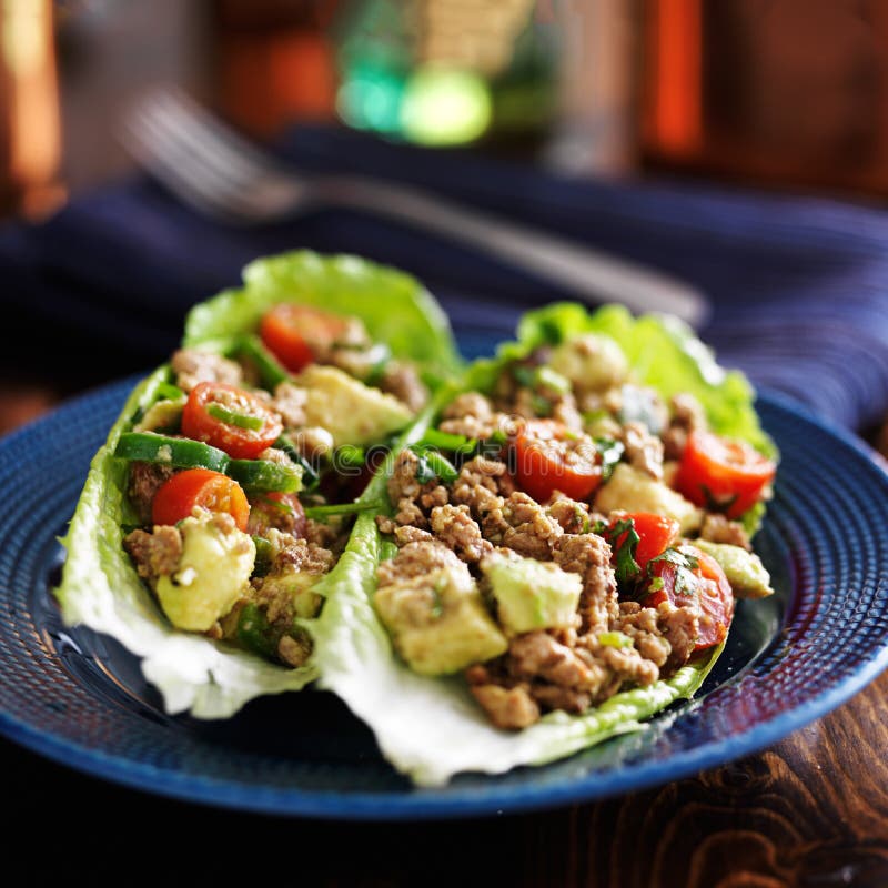 Avocado turkey lettuce wraps on plate on blue plate. Avocado turkey lettuce wraps on plate on blue plate