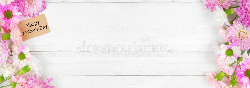 Happy Mothers Day gift tag with double border of pink and white flowers. Top down view on a white wood banner background. Copy space. Happy Mothers Day gift tag with double border of pink and white flowers. Top down view on a white wood banner background. Copy space