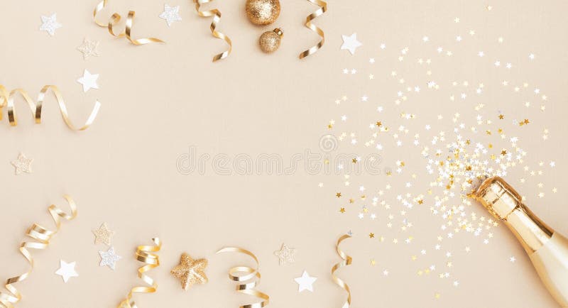 Champagne bottle with confetti stars, holiday decoration and party streamers on gold festive background. Christmas, birthday or wedding concept. Flat lay. Champagne bottle with confetti stars, holiday decoration and party streamers on gold festive background. Christmas, birthday or wedding concept. Flat lay