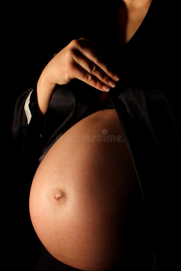A pregnant woman in a black silk robe. A pregnant woman in a black silk robe.