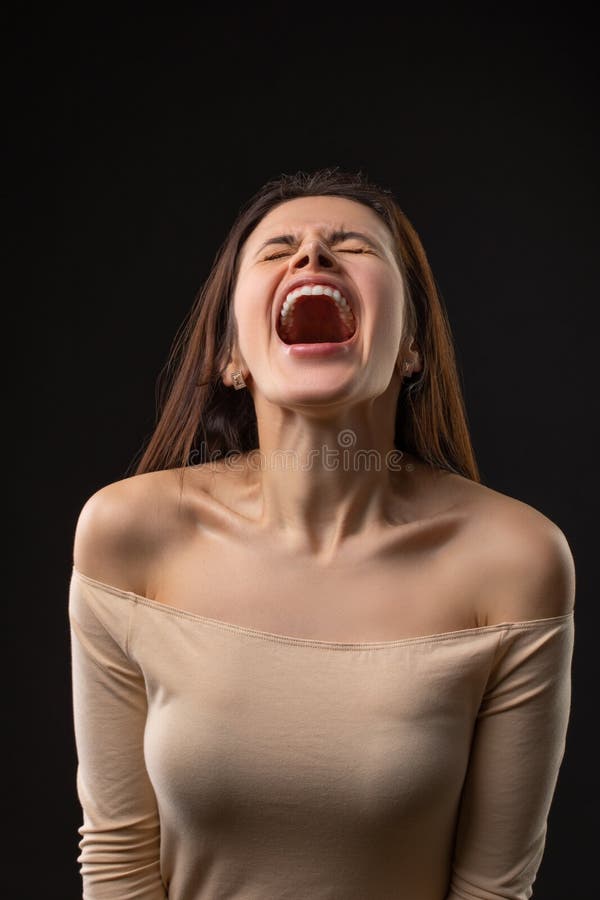 黑发女人在黑色背景中尖叫的画像 免版税库存图片 黑发女人在黑色背景中尖叫的画像 免版税库存图片