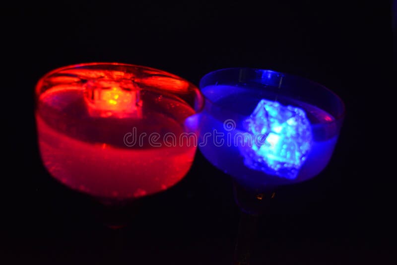 Bright multicolor doidic glowing ice cubes float in the drink. Very bright and colorful photographs and images of a holiday, corporate party, events using diode glowing ice cubes. A lot of bright colored ice cubes in festive drinks located on a black matte background. All these images are made in the city of Dnipro, Ukraine. Bright multicolor doidic glowing ice cubes float in the drink. Very bright and colorful photographs and images of a holiday, corporate party, events using diode glowing ice cubes. A lot of bright colored ice cubes in festive drinks located on a black matte background. All these images are made in the city of Dnipro, Ukraine.