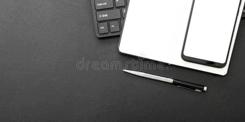 黑色办公桌，配备笔记本电脑、智能手机和其他工作用品，配备咖啡 具有用于输入的复制空间的顶视图 库存图片