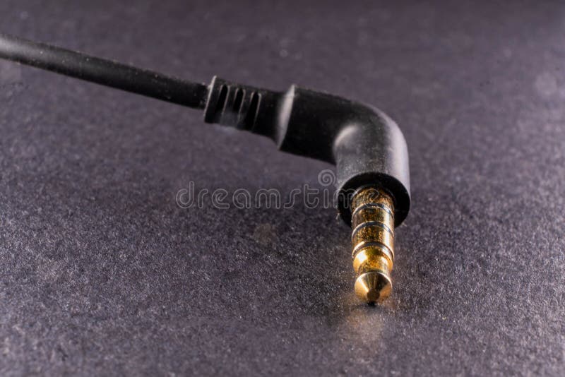 An image of a golden plated 3.5mm jack on a black background, showcasing the marriage of modern technology and aesthetic appeal. An image of a golden plated 3.5mm jack on a black background, showcasing the marriage of modern technology and aesthetic appeal.