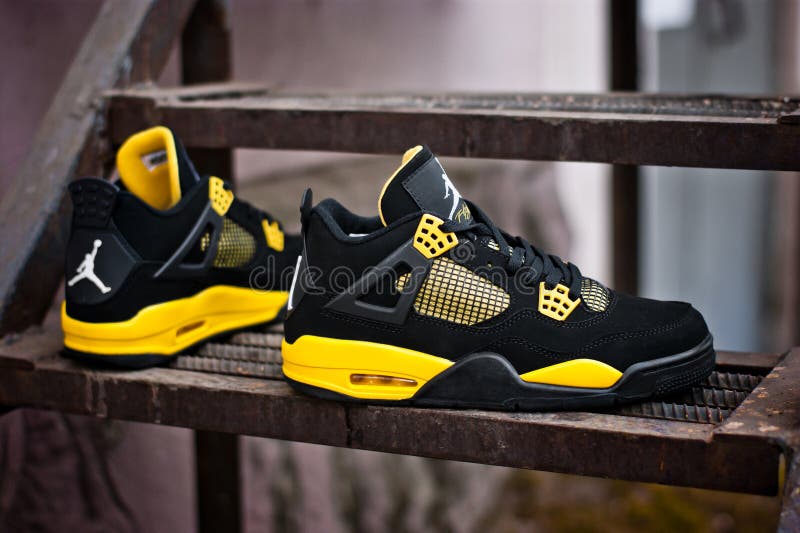 黑色黄色耐克Air Jordan IV 4复古鞋，在生锈的金属楼梯上 俄罗斯克拉斯诺亚尔斯克市 — 2015年2月11日 库存照片