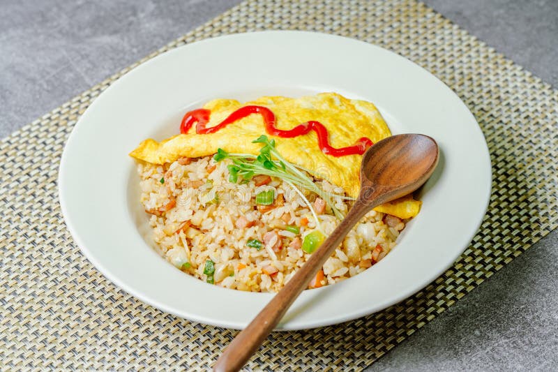 Vas de orez omletă servit pe o placă gri. Aliment omletă de orez cu ketchup servit pe o placă gri